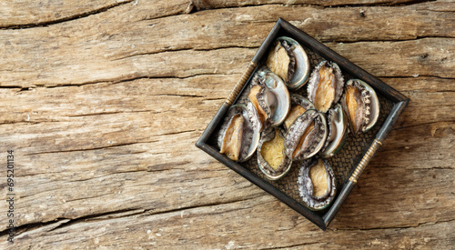 Fresh abalone on wooden plate photo