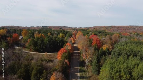 Autumn landscape in rural Caledon, Canada. Road with car traveling alone. Aerial photo