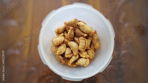 A jar of indonesian snack called pastel kering