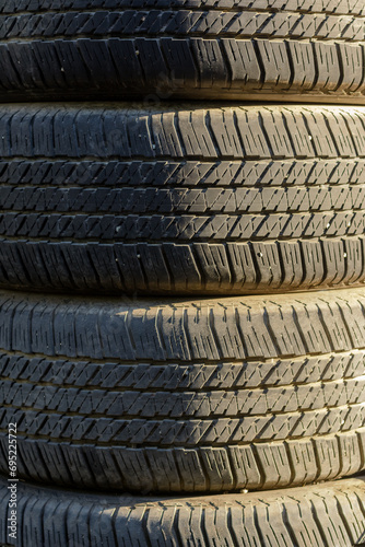 Stacked used car tires in natural light.