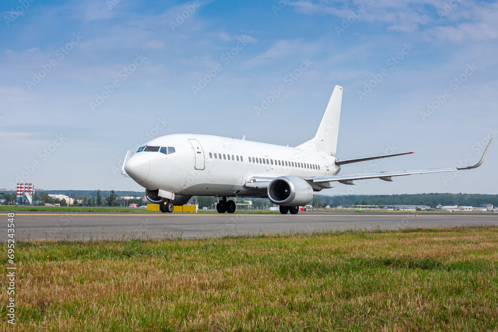 White passenger airliner taxiing on the main taxiway White passenger airliner taxiing on the main taxiway