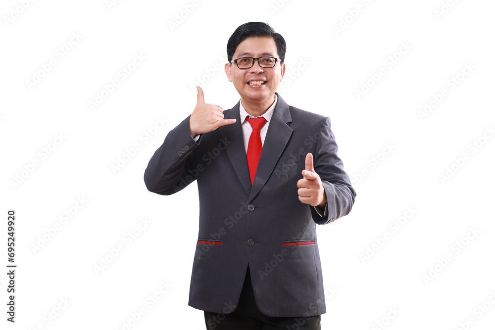 Happy friendly asian businessman standing while making phone hand gesture and pointing at you. Isolated on white