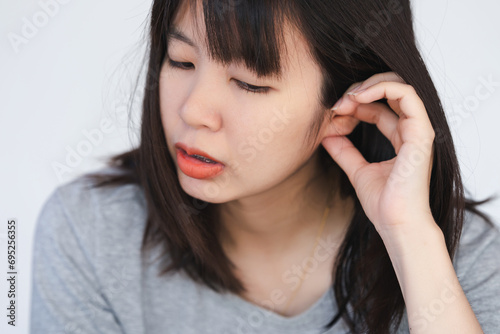 A woman has itching and irritation around her ears and inside her ears. photo
