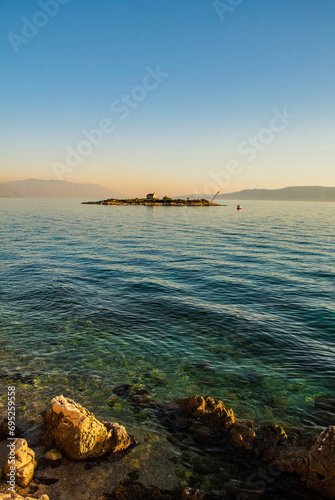 Late afternoon low sun at the island of San Marino off the Adriatic coast of Novi Vinodolski, Primorje-Gorski Kotar County, Croatia. Mid-September. Sv Martina chapel is the only building on the island photo