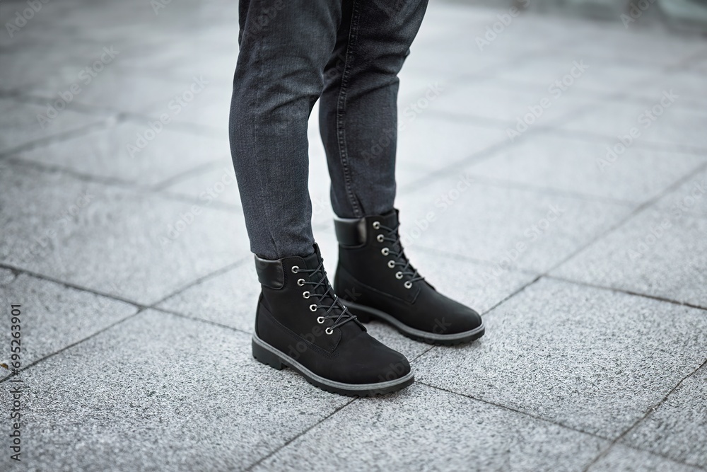 A pair of stylish dark brown leather boots paired with grey denim jeans captures the essence of modern urban fashion. A pair of stylish dark brown leather boots paired with grey denim jeans captures the essence of modern urban fashion.