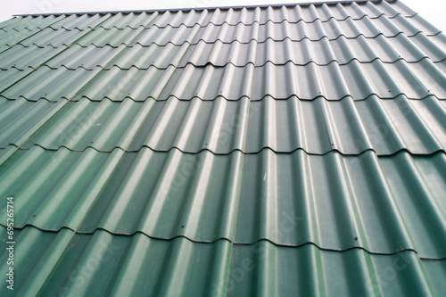 Modern roof. Roofing covering. Roman profile. The roof of the house is covered with wavy green tiles.