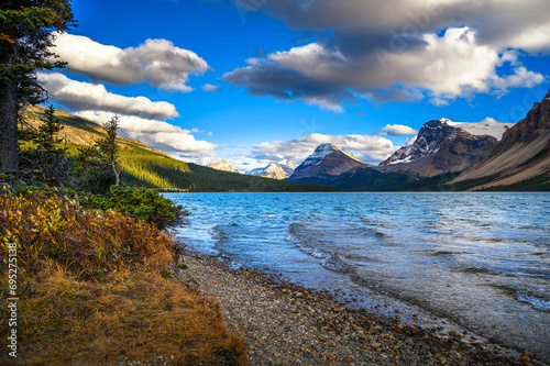 Bow Lake with waves and rugged mountains under a cloud-filled sky in Banff National Park, Canada.