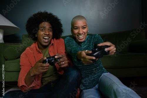 Couple playing a video game at home at night photo