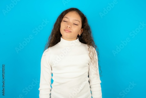 Young beautiful teen girl wearing white turtleneck over blue background nice-looking sweet charming cute attractive lovely winsome sweet peaceful closed eyes