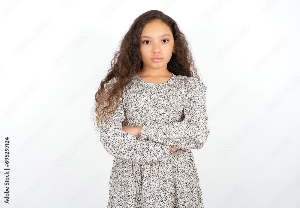 Serious pensive Beautiful teen gil wearing gray dress over white background feel like cool confident entrepreneur cross hands. Serious pensive Beautiful teen gil wearing gray dress over white background feel like cool confident entrepreneur cross hands.