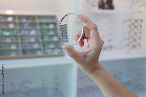 person holding glasses lenses in optical store