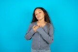 Beautiful teenager girl smiling with hands on chest with closed eyes and grateful gesture on face. Health concept.
