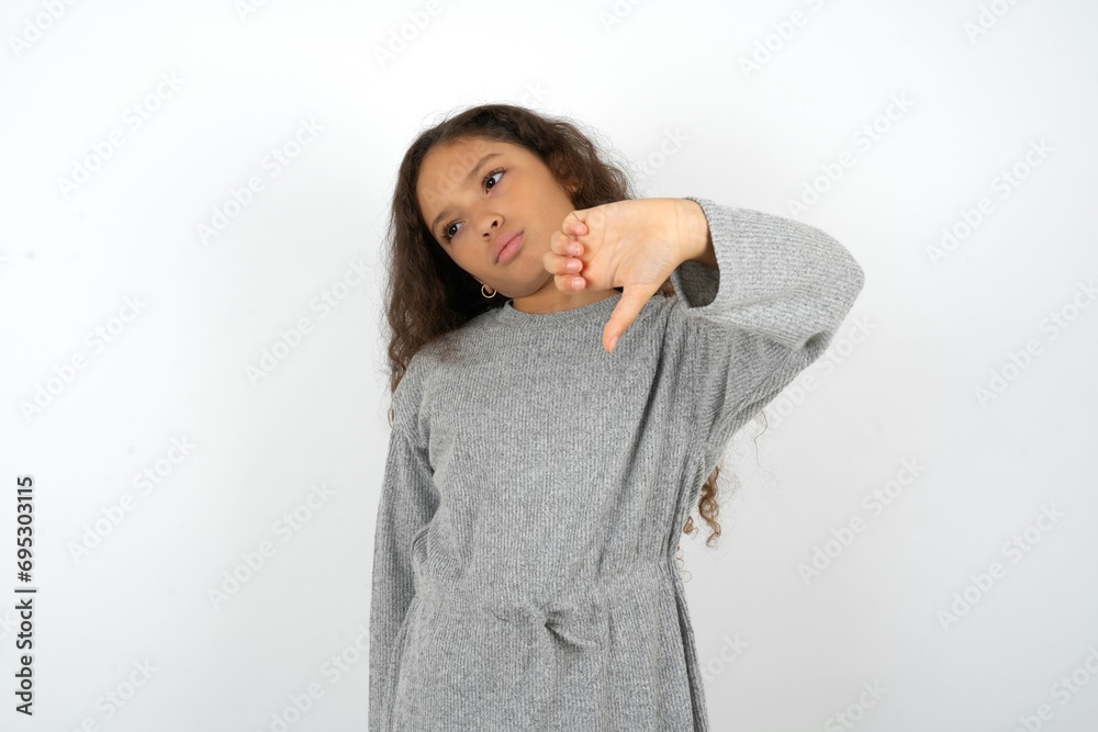 MODEL feeling angry, annoyed, disappointed or displeased, showing thumbs down with a serious look MODEL feeling angry, annoyed, disappointed or displeased, showing thumbs down with a serious look
