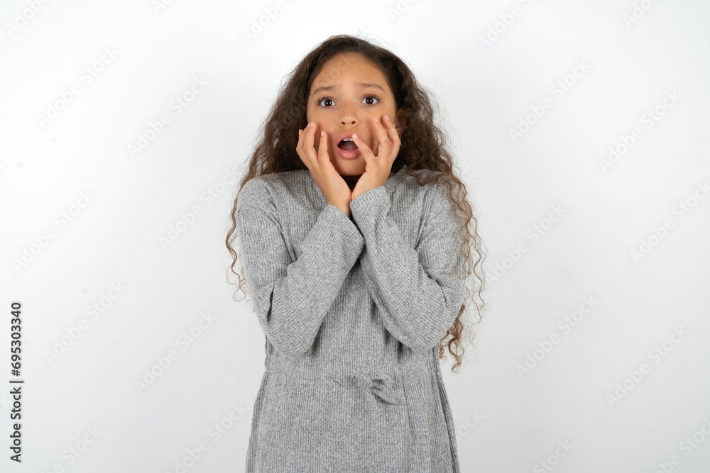 Stupefied MODEL expresses excitement and thrill, keeps jaw dropped, hands on cheeks, has eyes popped out Stupefied MODEL expresses excitement and thrill, keeps jaw dropped, hands on cheeks, has eyes popped out
