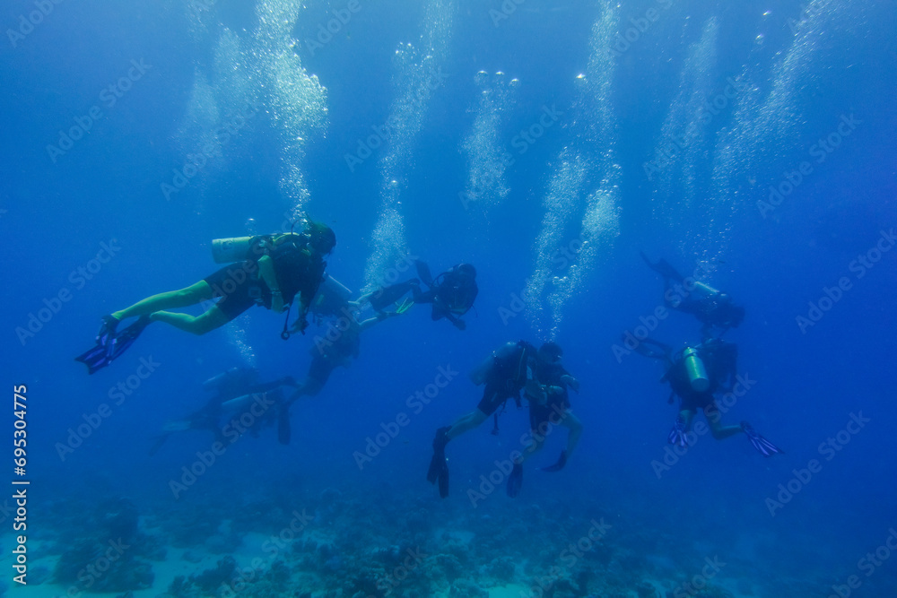 lot of diver with blubbles in deep blue water on vacation