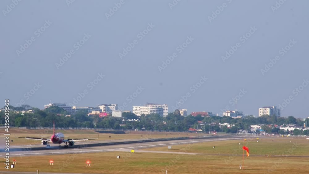A passenger plane landing on runway. Back view on landing airplane. Chassis touching down runway with smoke. A passenger plane landing on runway. Back view on landing airplane. Chassis touching down runway with smoke.