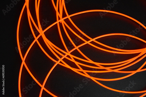 Unusual glowing background of chaotically stacked thin light wires  red glowing tourniquet  illuminated  thin wire placed on a thin background.