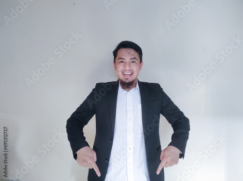 Asian businessman smiling confident with both hands pointing below photo