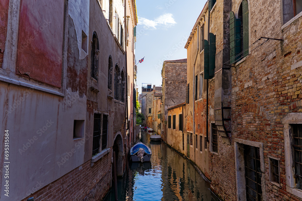 Old town of Italian City of Venice with scenic view of canal with moored boats on a sunny summer day. Photo taken August 7th, 2023, Venice, Italy.