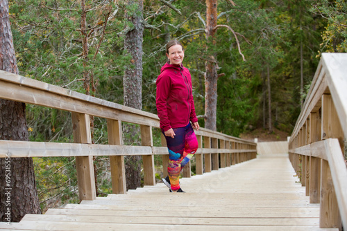 Athletic middle-aged woman running up the Fitness Stairs in a natural park in the woods