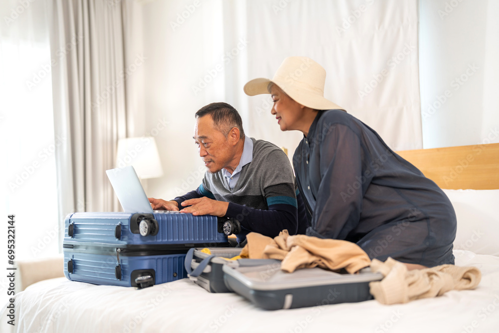 Senior elderly asian couple use laptop for hotel and resort booking online summer holiday travel planning searching information weekend vacation trip.reservation online, senior retirement concept Senior elderly asian couple use laptop for hotel and resort booking online summer holiday travel planning searching information weekend vacation trip.reservation online, senior retirement concept