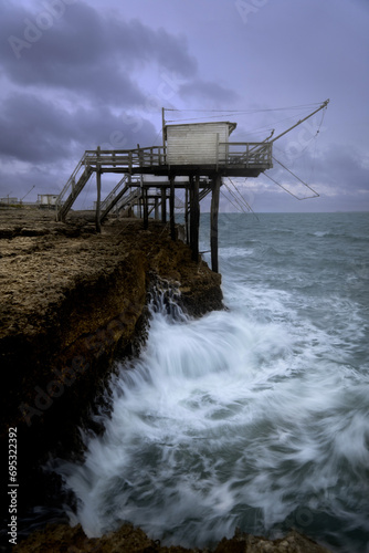 Carrelet de Saint Palais sur Mer in front of a rough sea and a dark sky