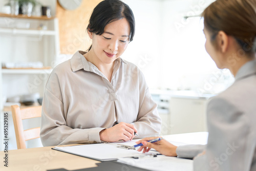 セールスの話を聞くアジア人女性