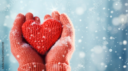 A woman holds a knitted heart in her hands. Selective focus.