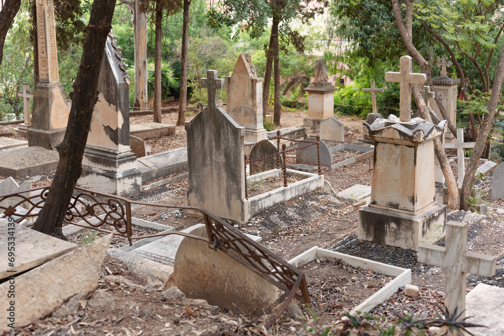 old tombs in an English Victorian cemetery full of dry leaves on the ground. old tombs in an English Victorian cemetery full of dry leaves on the ground.
