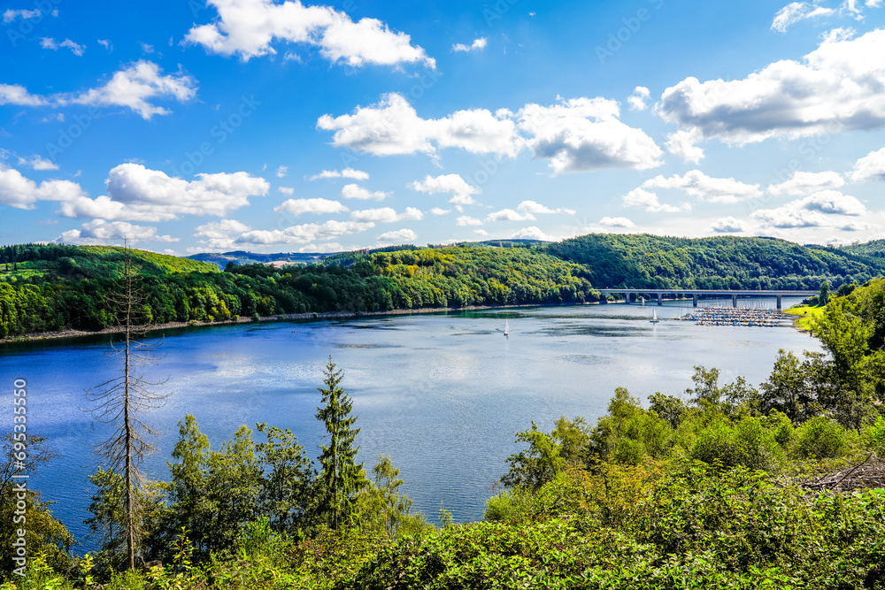 View of the Biggesee near Attendorn in the Olpe district with the surrounding nature. Landscape by the lake in the Sauerland. Bigge Dam.
View of the Biggesee near Attendorn in the Olpe district with the surrounding nature. Landscape by the lake in the Sauerland. Bigge Dam.