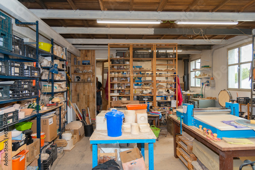 Shelves with various tools in pottery workshop photo