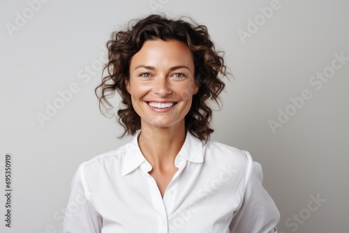 Portrait of a smiling woman in her 40s wearing a simple cotton shirt against a white background. AI Generation