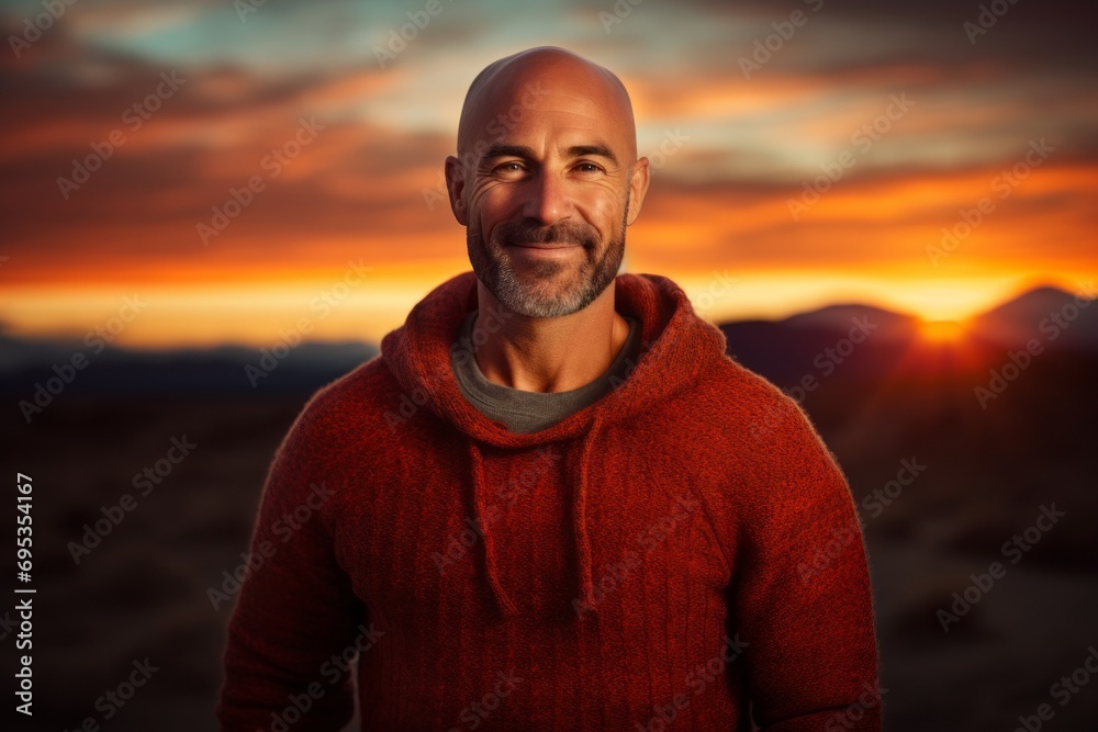 Portrait of a smiling man in his 40s dressed in a warm wool sweater against a vibrant sunset horizon. AI Generation Portrait of a smiling man in his 40s dressed in a warm wool sweater against a vibrant sunset horizon. AI Generation