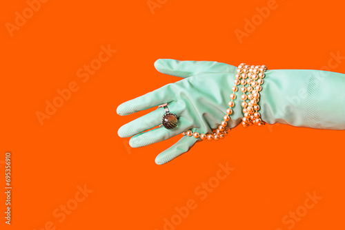 Elegant accessory on mint glove against orange backdrop