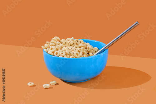 Blue bowl of cereal with milk on an orange background photo