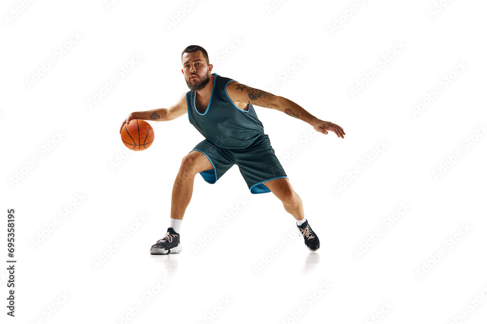 Dynamic portrait of professional basketball player, fit man honing skills with precision dribbling against white background. Dynamic portrait of professional basketball player, fit man honing skills with precision dribbling against white background.