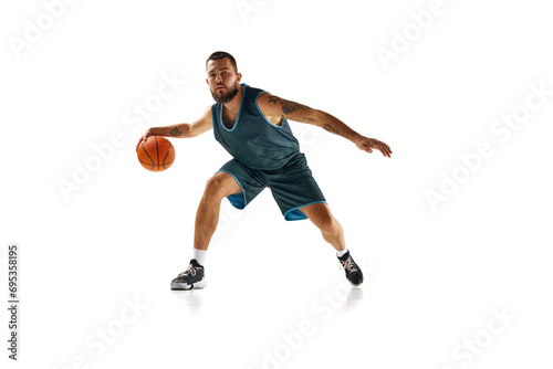 Dynamic portrait of professional basketball player, fit man honing skills with precision dribbling against white background.