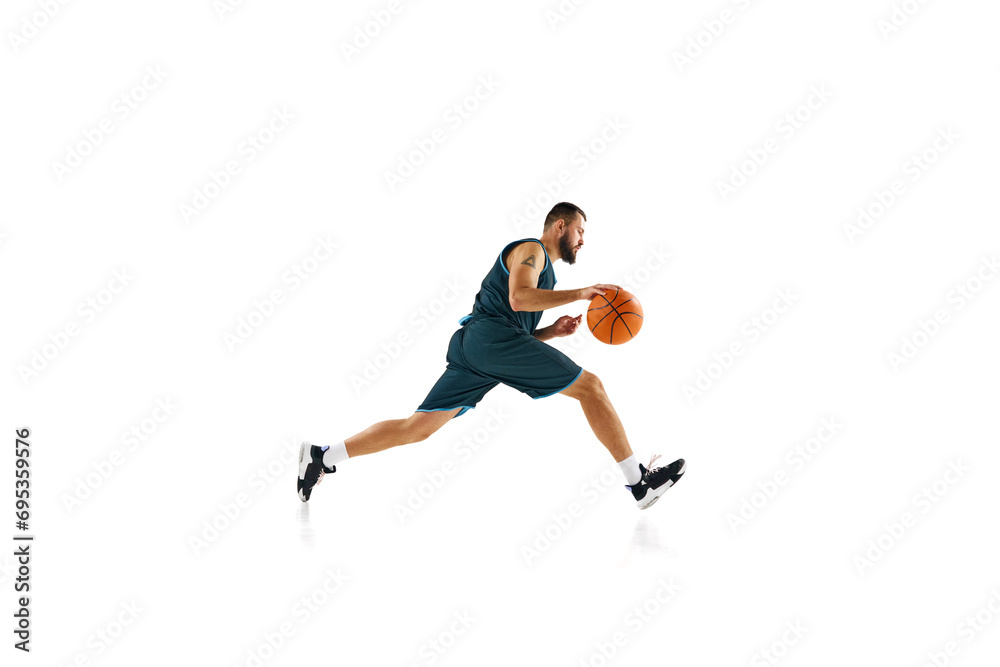 Dynamic, energetic portrait of sportsman, basketball player training slam dunk technique against white background.