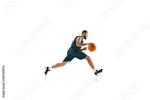 Dynamic, energetic portrait of sportsman, basketball player training slam dunk technique against white background.