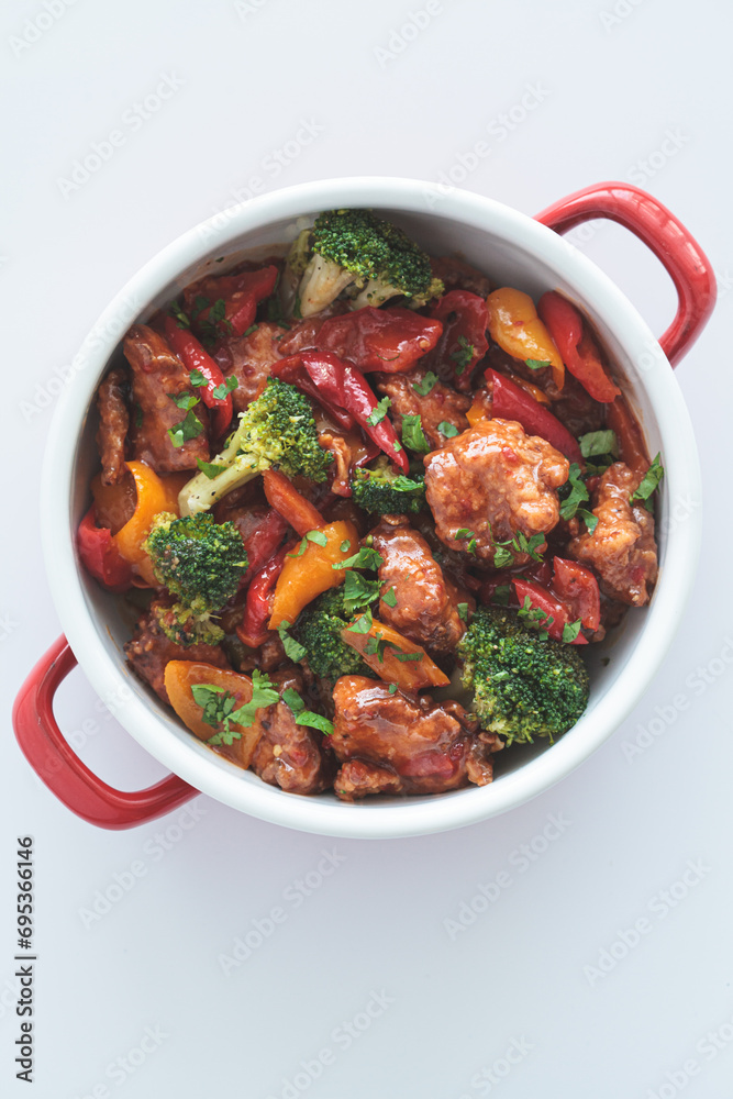 Stewed chicken fillet with vegetables in pan, white background. Stewed chicken fillet with vegetables in pan, white background.
