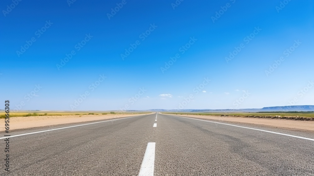 highway in the grassland background of blue sky and bright clouds, long road stretches into the distance. empty street on a beautiful sunny day