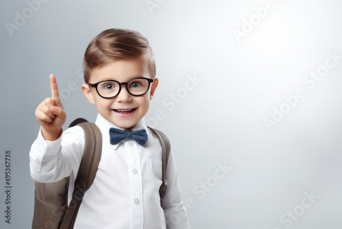 Smiling child boy pointing his index finger at something on white background Success, creative and innovation concept. eureka, handsome little boy in glasses is surprised