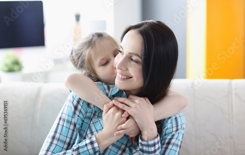 Little girl hugging young woman at home. Happiness of motherhood concept
