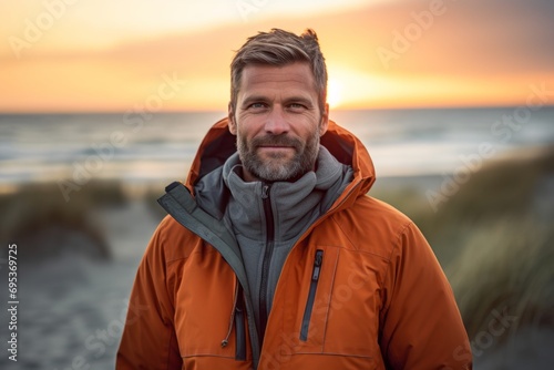 Portrait of a glad man in his 40s wearing a warm parka against a beautiful beach sunset. AI Generation