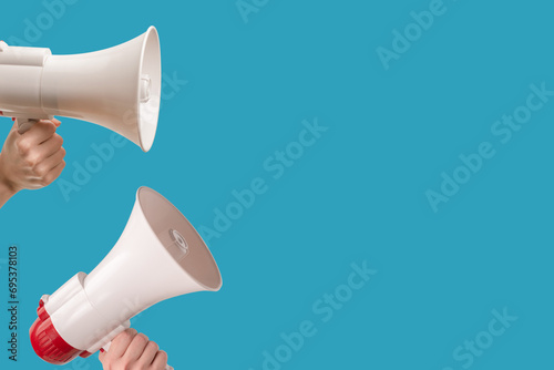 Megaphone in woman hands on a blue background.