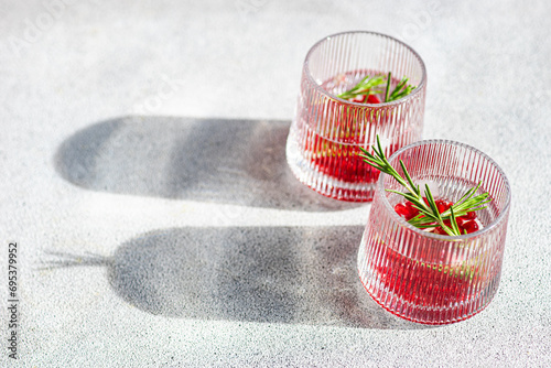 Sunlit gin tonic with pomegranate in concrecte background photo