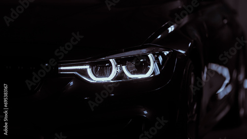 Black modern car headlights - front view. Silhouette of black sports car with headlights close up.