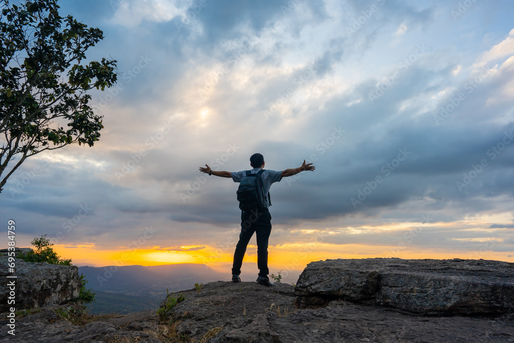 Alone man travel and sitting on cliff of hill and see view of sunset sky background