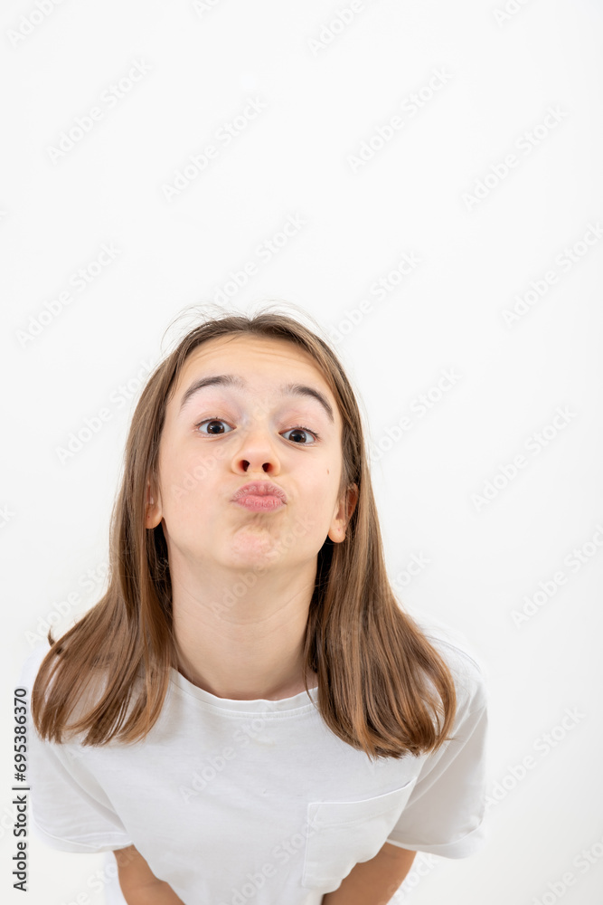 Funny teenage girlput her lips together for a kiss on a white background. Funny teenage girlput her lips together for a kiss on a white background.