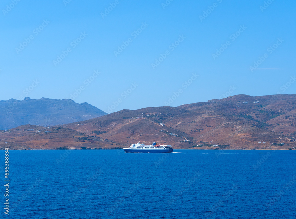 A ferry boat in the sea against the background of Tinos Island in Greece